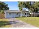 Charming single-story home featuring a well-maintained lawn and inviting front porch at 5932 Mckee Lake N Dr, St Petersburg, FL 33709