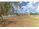 Spacious backyard with ample room for outdoor activities, complemented by a charming tree and a secure fence at 5939 14Th St, Zephyrhills, FL 33542