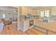 Cozy kitchen features white cabinetry, tile backsplash, modern appliances, and views to the living room at 5939 14Th St, Zephyrhills, FL 33542