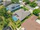 Aerial view of a home with a screened pool, patio furniture, and lush landscaping at 6104 Cognac Cir, Lutz, FL 33558