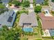 Aerial view of home featuring a screened pool, well-manicured landscaping, and a tile roof at 6104 Cognac Cir, Lutz, FL 33558