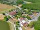 Aerial view of a clubhouse featuring several buildings, parking, landscaping, and pond views at 6104 Cognac Cir, Lutz, FL 33558