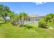 Backyard view of pool and patio with lush landscaping, all enclosed by a screen at 6104 Cognac Cir, Lutz, FL 33558