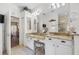 A bathroom features double vanity, a large mirror, and a partial view of the bedroom at 6104 Cognac Cir, Lutz, FL 33558