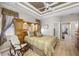 A primary bedroom features a ceiling fan, wood floors, and upholstered chair at 6104 Cognac Cir, Lutz, FL 33558