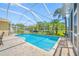 Sparkling in-ground pool with a screened enclosure and brick-paved patio at 6104 Cognac Cir, Lutz, FL 33558