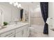 Well-lit bathroom with a clean, white vanity, framed mirror, and a shower-tub combination with stylish curtains at 6137 Wire Grass Ct, Nokomis, FL 34275
