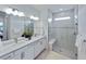 Elegant bathroom featuring double sinks, a spacious glass-enclosed shower, and stylish fixtures for a spa-like experience at 6137 Wire Grass Ct, Nokomis, FL 34275