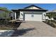 Beautiful home featuring a two-car garage, a paved driveway, and lush landscaping at 6137 Wire Grass Ct, Nokomis, FL 34275