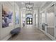 Hallway with decorative paintings, bench seating, and view into outdoor landscape at 6137 Wire Grass Ct, Nokomis, FL 34275