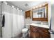 Well-lit bathroom with a wood vanity and wood medicine cabinet over the toilet at 710 N Village N Dr # 102, St Petersburg, FL 33716