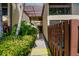 Exterior daytime view of a condo entrance with walkway, fence and tropical plants at 710 N Village N Dr # 102, St Petersburg, FL 33716