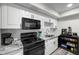 Bright kitchen boasts white cabinets, subway tile backsplash, and black appliances at 710 N Village N Dr # 102, St Petersburg, FL 33716