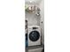 Well-lit laundry room with a full-size washing machine and metal shelving above at 710 N Village N Dr # 102, St Petersburg, FL 33716