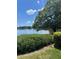 Lakeside view with a large shade tree and vibrant flowers offering a serene environment at 710 N Village N Dr # 102, St Petersburg, FL 33716