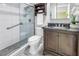 Modern bathroom featuring a glass-enclosed shower, tiled walls, and a vanity with a dark countertop at 7242 55Th N Ave, St Petersburg, FL 33709