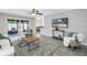 Bright living room featuring tile flooring, a ceiling fan, and sliding glass doors to the outside at 7242 55Th N Ave, St Petersburg, FL 33709