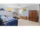 Spacious bedroom showcasing a bed, treadmill, armoire, and natural light, creating a comfortable living space at 7534 Culberson Dr, Port Richey, FL 34668