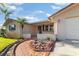Inviting home exterior featuring a rock garden, palm tree, and a paved walkway at 7534 Culberson Dr, Port Richey, FL 34668