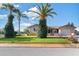 Well-maintained home exterior with mature trees, a green lawn, and a clear blue sky at 7534 Culberson Dr, Port Richey, FL 34668