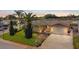 Charming single-story home featuring a well-manicured lawn, mature landscaping, and a driveway leading to an attached garage at 7534 Culberson Dr, Port Richey, FL 34668
