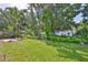 Lush backyard with stone path, mature landscaping, and green lawn at 7649 Nottinghill Sky Dr, Apollo Beach, FL 33572