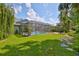 Beautiful backyard with screened pool enclosure, lawn, and tropical foliage at 7649 Nottinghill Sky Dr, Apollo Beach, FL 33572
