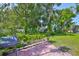 Charming backyard featuring brick pavers, a grill, and lush greenery at 7649 Nottinghill Sky Dr, Apollo Beach, FL 33572