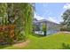 Backyard featuring screened pool enclosure, mature landscaping, and lush green lawn at 7649 Nottinghill Sky Dr, Apollo Beach, FL 33572