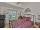 Cozy bedroom with iron bed frame and comfortable mattress, complemented by a bright window view at 7649 Nottinghill Sky Dr, Apollo Beach, FL 33572