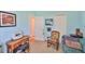 Bright bedroom with soft carpet, featuring a wooden desk and colorful floral rocking chair at 7649 Nottinghill Sky Dr, Apollo Beach, FL 33572