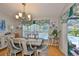 Dining room showcasing hardwood floors, stylish chandelier, and views of the backyard pool at 7649 Nottinghill Sky Dr, Apollo Beach, FL 33572