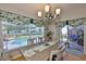Dining room with hardwood floors, chandelier, and slider view of the pool and outdoor seating area at 7649 Nottinghill Sky Dr, Apollo Beach, FL 33572