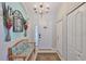 Inviting foyer with stylish chandelier, decorative mirror, bench, and tiled floor, creating a warm welcome at 7649 Nottinghill Sky Dr, Apollo Beach, FL 33572