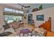 Sunlit living room featuring vaulted ceilings, hardwood floors, and an entertainment center with ample storage at 7649 Nottinghill Sky Dr, Apollo Beach, FL 33572
