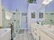 Modern main bathroom features a glass enclosed shower, soaking tub, double vanity, and stylish fixtures at 7649 Nottinghill Sky Dr, Apollo Beach, FL 33572