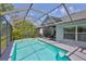 Beautiful screened pool with lush greenery and access to an outdoor patio at 7649 Nottinghill Sky Dr, Apollo Beach, FL 33572