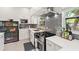 Bright kitchen featuring modern stainless steel appliances, tile backsplash, and white cabinetry at 8239 26Th N Ave, St Petersburg, FL 33710