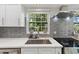 Close-up of the kitchen featuring a stainless steel sink, tile backsplash, and granite countertops at 8239 26Th N Ave, St Petersburg, FL 33710