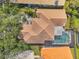Aerial view of a house with a terra cotta tile roof, pool, and mature landscaping at 980 Live Oak Ne Ave, St Petersburg, FL 33703