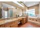 Bathroom with a large mirror above a double sink vanity, and a separate soaking tub and shower at 980 Live Oak Ne Ave, St Petersburg, FL 33703