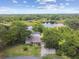 Aerial view of lakeside home with a pool and beautifully landscaped yard at 1703 Ryan Dr, Lutz, FL 33549