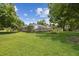 Spacious backyard featuring a large screened lanai, lush lawn, and mature trees, perfect for outdoor living at 1703 Ryan Dr, Lutz, FL 33549