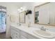 Bright and airy bathroom featuring double sinks, framed mirrors, and walk in shower at 1703 Ryan Dr, Lutz, FL 33549
