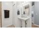 Modern bathroom with pedestal sink, tiled floors, a mirror, and white wainscoting at 1703 Ryan Dr, Lutz, FL 33549