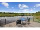 Private dock on a serene lake, furnished with table and chairs at 1703 Ryan Dr, Lutz, FL 33549