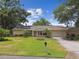 Charming single-story home with a well-manicured lawn and lush landscaping at 1703 Ryan Dr, Lutz, FL 33549