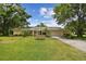 Charming one-story home with well-manicured lawn, mature trees, and a welcoming entrance at 1703 Ryan Dr, Lutz, FL 33549