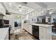 Bright and airy kitchen with white cabinetry and modern appliances flows to a dining space at 1703 Ryan Dr, Lutz, FL 33549