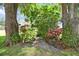 Beautiful landscaping featuring a stone path, mature trees, and lush greenery creating a serene outdoor setting at 1703 Ryan Dr, Lutz, FL 33549